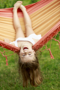 Summer fun - lovely girl playing in hammock